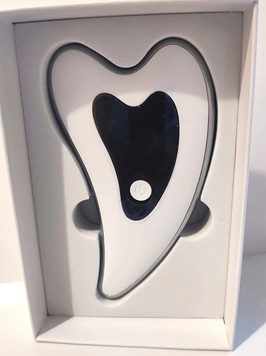 Heated vibrating gua sha facial massager device, heart-shaped white and black design